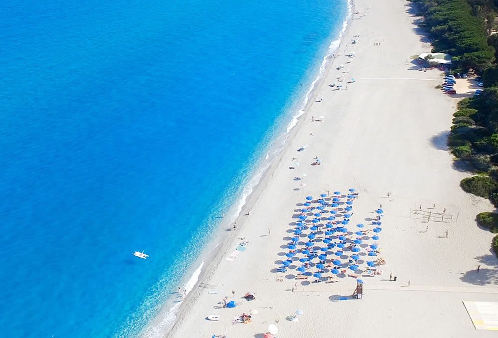 La foto è una ripresa dall'alto della spiaggia di Bari Sardodel campeggio e include lo stabilimento con ombrelloni e la torretta del bagnino